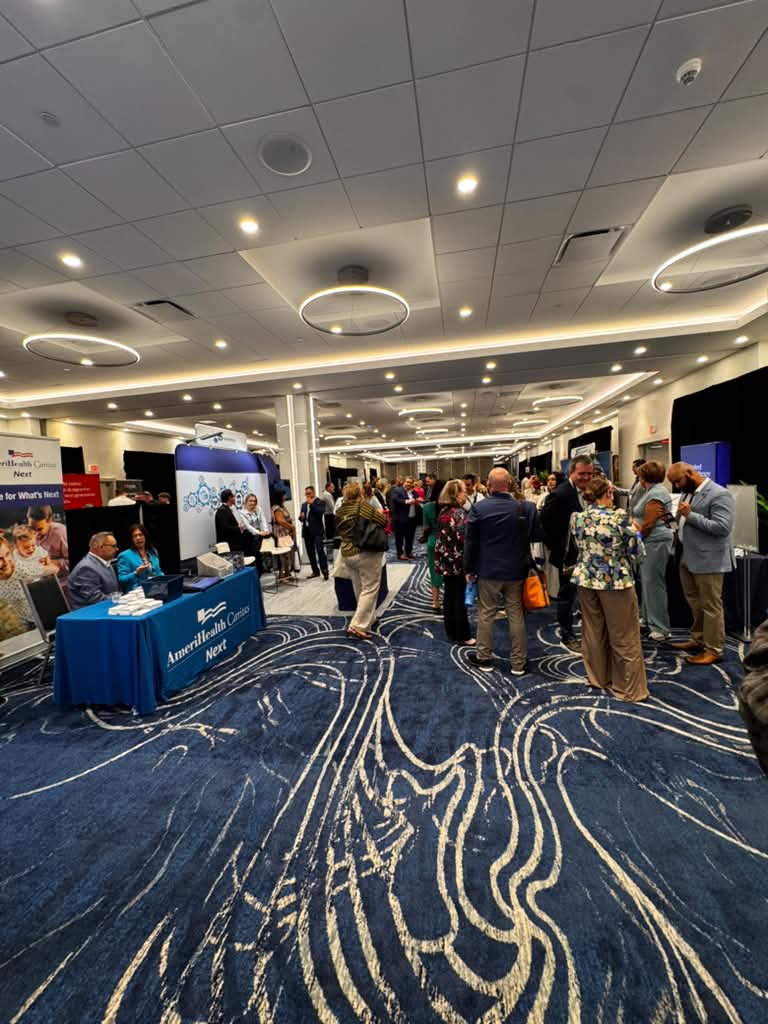 Vista general del salón de ACA Way en Miami con asistentes y stands de compañías de seguros de salud.