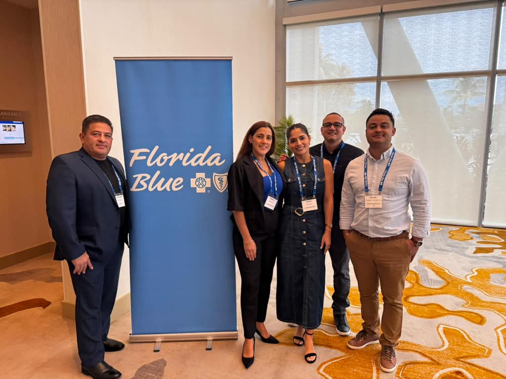 Equipo de Live Insurance 2020 LLC frente al cartel de Florida Blue durante la presentación.